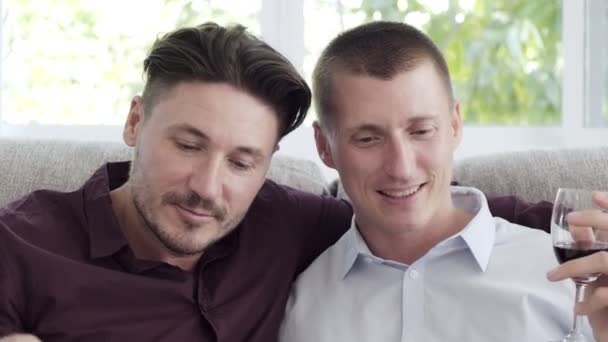 Caucasiano Gay Casal Leitura Livro Beber Vinho Casa — Vídeo de Stock