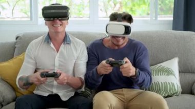 Kafkas eşcinsel çift evde joystics video oyunu oynuyor ve sanal gerçeklik gözlük giyiyor 