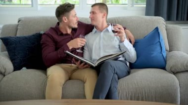 Kafkas eşcinsel çift evde şarap içiyor ve kitap okuyor 