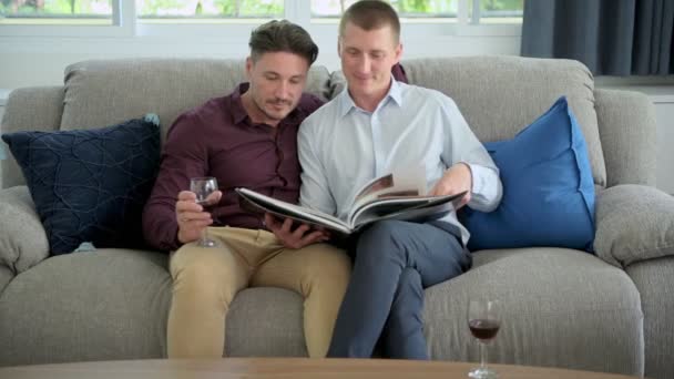 Caucasiano Gay Casal Beber Vinho Leitura Livro Casa — Vídeo de Stock