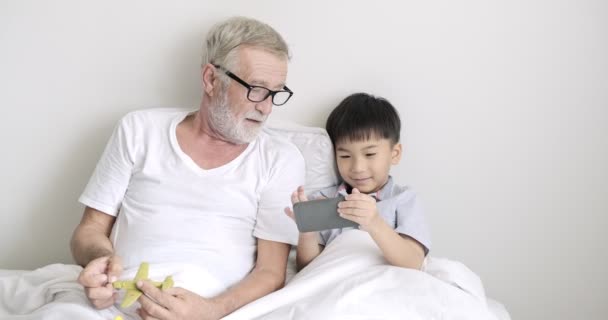 Mladý Asijský Chlapec Používá Mobilní Telefon Svým Dědečkem Klinice — Stock video