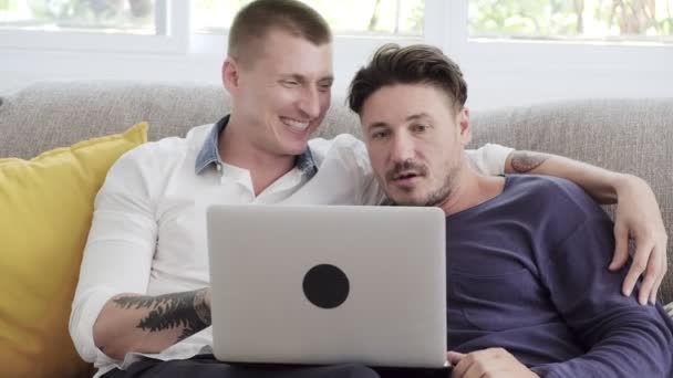 白人ゲイのカップルは 自宅でラップトップコンピュータを使用しています — ストック動画