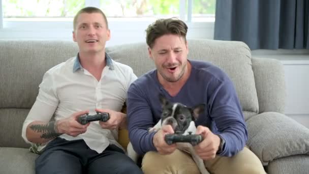 白人のゲイのカップルは 自宅で喜びでビデオゲームをプレイしています — ストック動画
