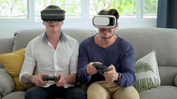 白人のゲイのカップルは 自宅で喜びにビデオゲームをプレイし バーチャルリアリティメガネを着用しています — ストック動画