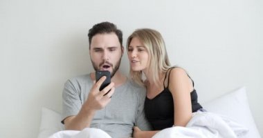 Canlı yayında cep telefonu kullanan çift, yatakta arkadaşlarıyla görüntülü konuşma, sürpriz. Beyaz erkek ve kadın..