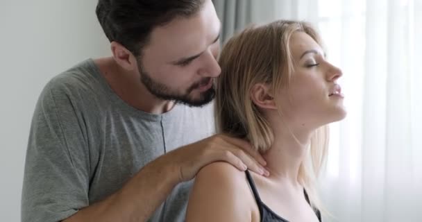 ベッドで女性の肩マッサージを与える男のクローズアップ 白人男性と女性 ひげと愛と関係の概念 — ストック動画