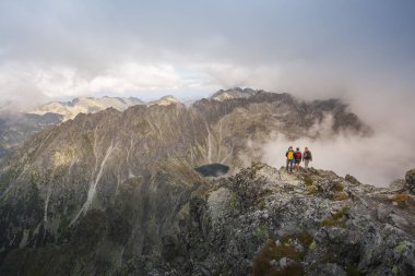 Hiking in the Tatra National Park Slovakia, Poland. Landscpes and panorama with mountain range. Clouds and Fog around the hikers. clipart