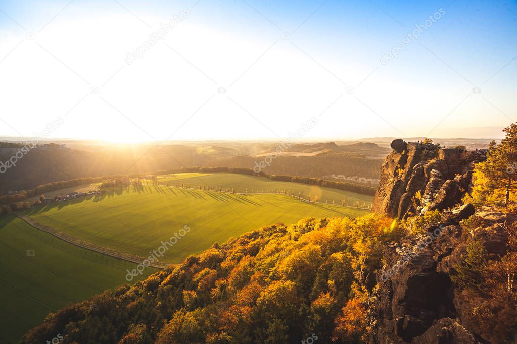 Great sunset light at the peak of an mesa in the german Saxon Switzerland National Park close to Dresden. Hiking and climbing in wonderful mountain ranges of the Elbe Sandstone Mountains.