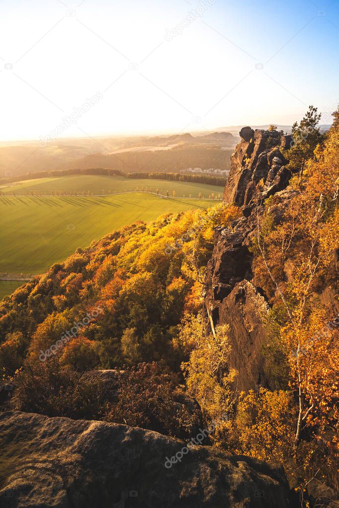 Great sunset light at the peak of an mesa in the german Saxon Switzerland National Park close to Dresden. Hiking and climbing in wonderful mountain ranges of the Elbe Sandstone Mountains.