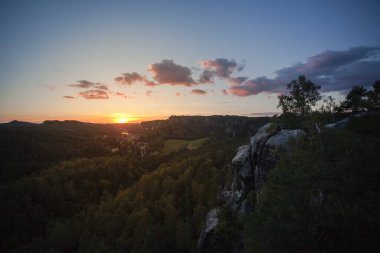 Sabah Elbe Kum Taşı Dağları 'nda harika bir atmosfer var. Güneş doğuyor ve ışık geliyor. Orman ve mointain ile harika bir manzara. Sıcak hava balonu uçuyor.