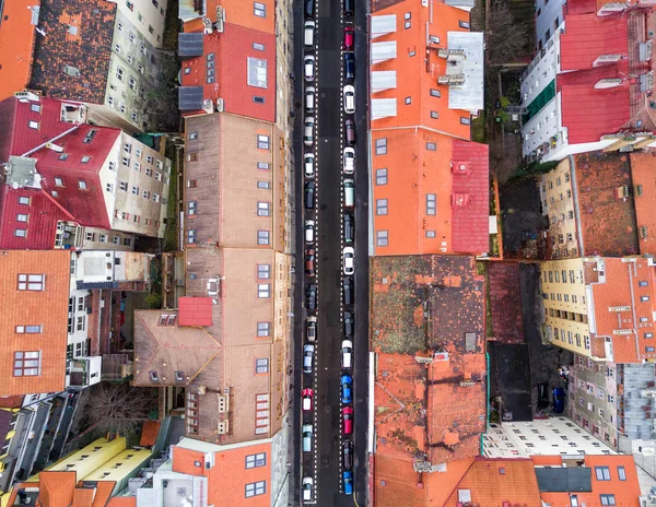 Luftaufnahme von oben über die Prager Altstadt, orangefarbene Dächer und eine winzige Straße mit vielen bunten Autos — Stockfoto