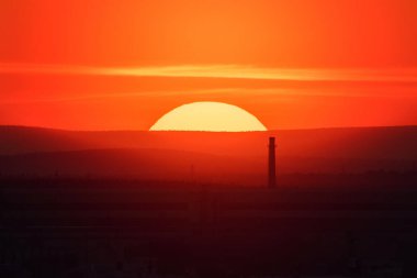 Ekaterinburg, Rusya - Jule, 2018: Yaz akşamı dev güneşle gün batımında megalopolis manzarasına sahip telefoto lens panoramik çekim