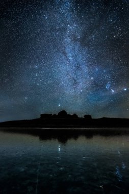 Dağların silueti üzerinde yıldızlı gece gökyüzü. Samanyolu.