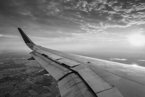 Φτερό ενός αεροπλάνου που πετούν πάνω από τα σύννεφα στο ηλιοβασίλεμα . — Φωτογραφία Αρχείου