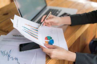 Ekonomik tablolar ve dizüstü bilgisayarlarla iş kadını eli 