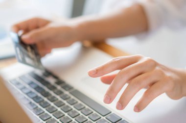 kredi kartı tutan ve dizüstü bilgisayar kullanarak çevrimiçi eller