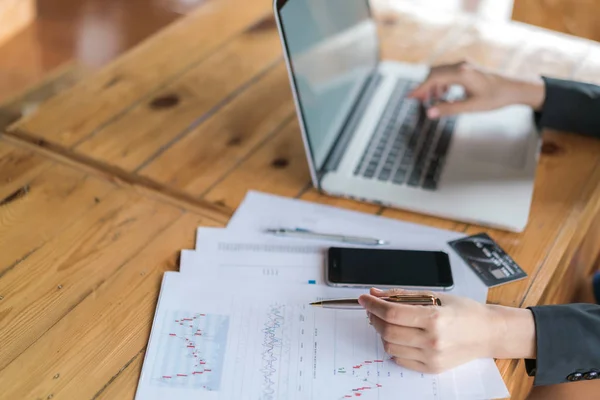 Femme d'affaires main avec des tableaux financiers et ordinateur portable — Photo