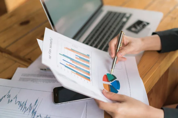 Geschäftsfrau mit Finanzdiagrammen und Laptop — Stockfoto