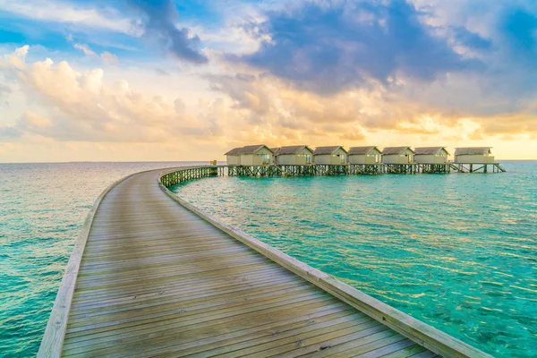 Belles villas aquatiques dans l'île tropicale des Maldives au coucher du soleil — Photo