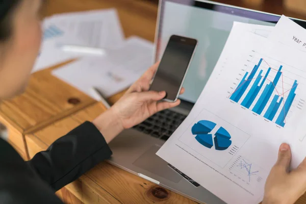 Business kvinna hand med finansiella diagram och laptop på bordet — Stockfoto