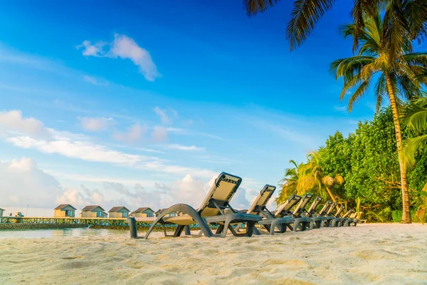 Chaises de plage dans l'île des Maldives avec villas aquatiques au lever du soleil — Photo