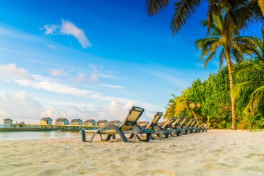 Plaj sandalyeleri Maldivler Island ile güneşin doğuşunu, su Villa