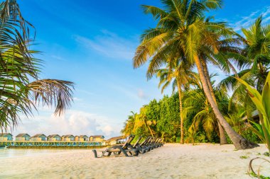 Plaj sandalyeleri Maldivler Island ile güneşin doğuşunu, su Villa