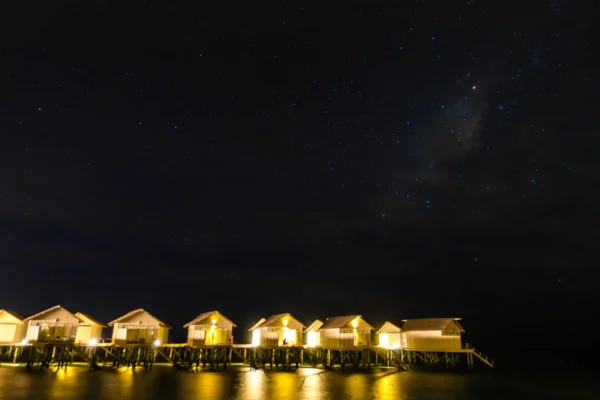 Abstract vervagen Melkweg boven water villa cottages op de Maldiven . — Stockfoto