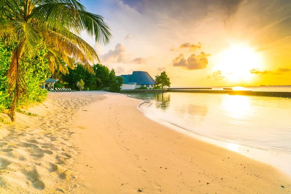 Hermoso amanecer sobre la playa con las villas de agua en tropical M — Foto de Stock