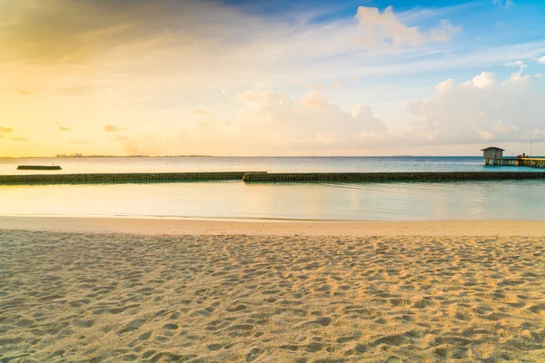 Hermoso amanecer sobre la playa con las villas de agua en tropical M — Foto de Stock