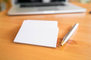 Ahşap yüzeyde boş kartvizitler ve dizüstü bilgisayar 