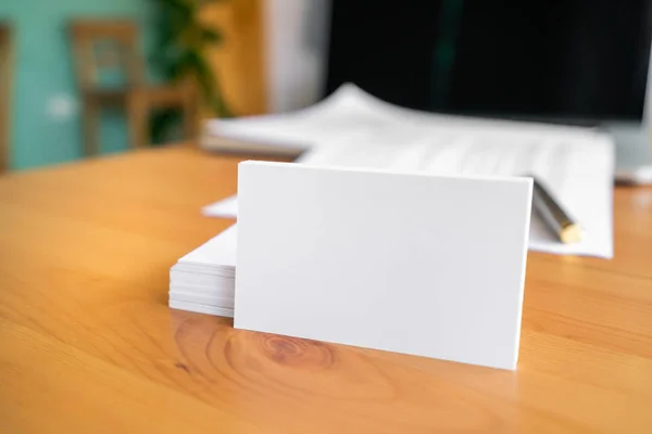 Tarjetas de visita en blanco y portátil en superficie de madera — Foto de Stock