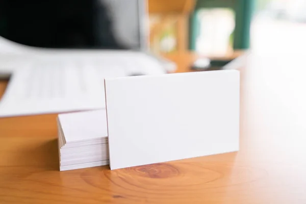 Cartões de visita em branco e laptop na superfície de madeira — Fotografia de Stock
