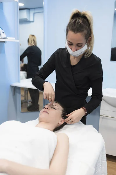 Cosmetologo Rimuovendo Peli Del Viso Con Threading Nella Stanza Della — Foto Stock