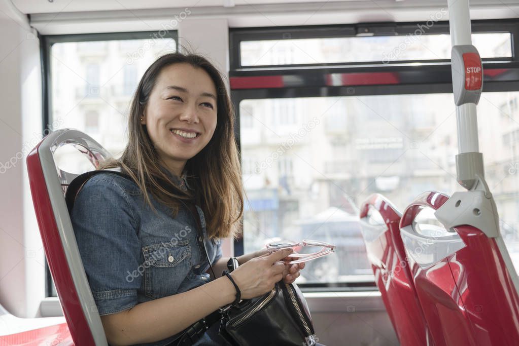 Asiatic woman traveling in a public bus