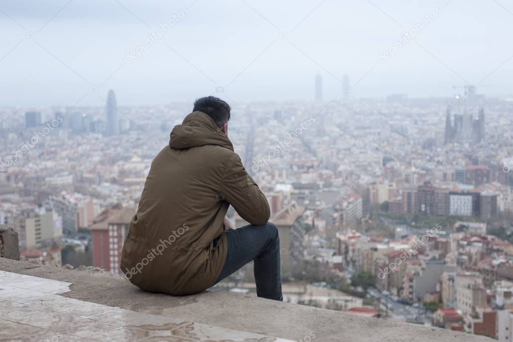 back view photo of man in coat enjoys the view at famous EL Carmel Bunkers in Barcelona