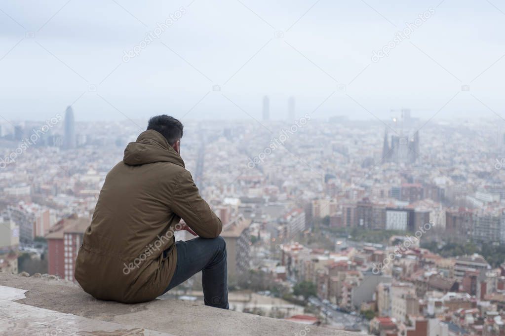 back view photo of man in coat enjoys the view at famous EL Carmel Bunkers in Barcelona