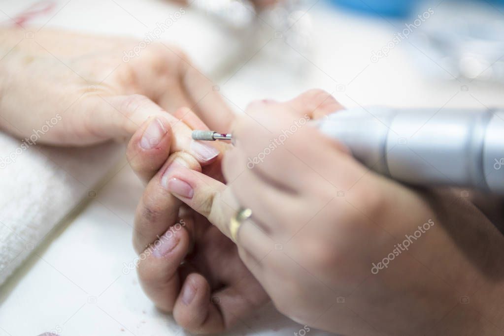 close-up shot of female hands at manicure process in beauty salon