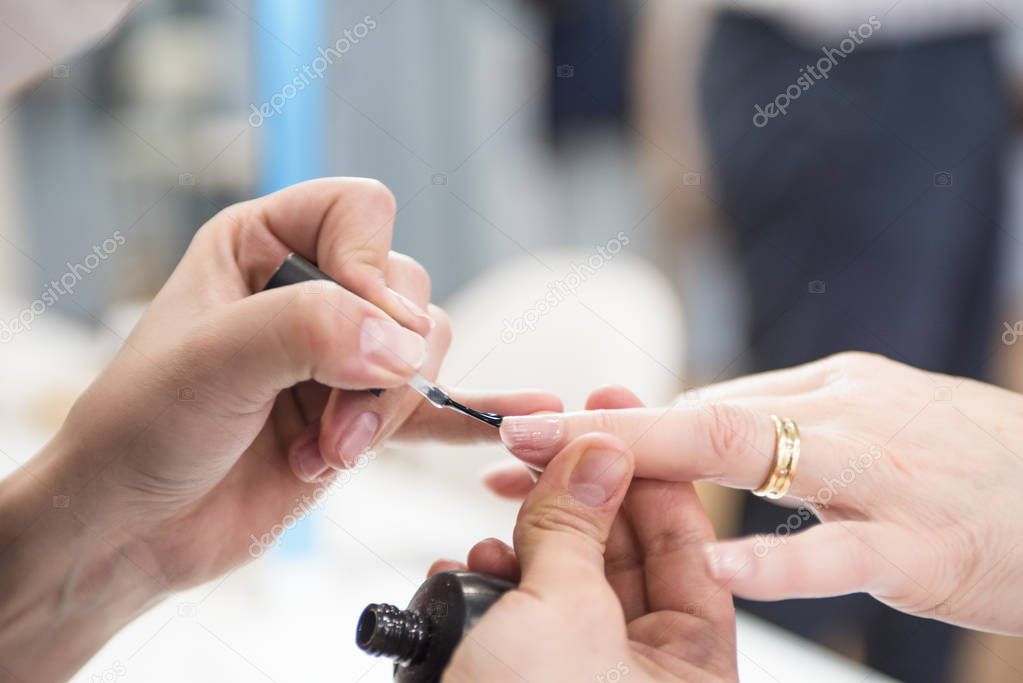 close-up shot of female hands at manicure process in beauty salon