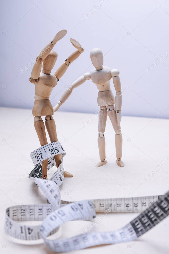 wooden mannequins couple with measure tape. nutritional concept 