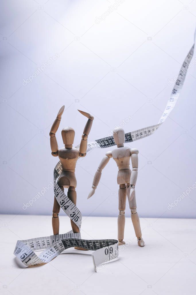 wooden mannequins couple with measure tape. nutritional concept 