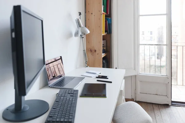 photo of computer, notebook and digital tablet on table of home office