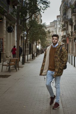 Sokakta yürüyen yakışıklı genç adam.