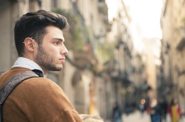 Sokakta yürüyen yakışıklı genç adam.