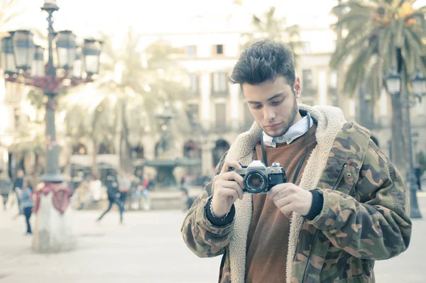 handsome young man taking pictures at the street