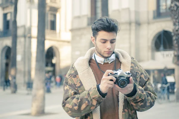 handsome young man taking pictures at the street