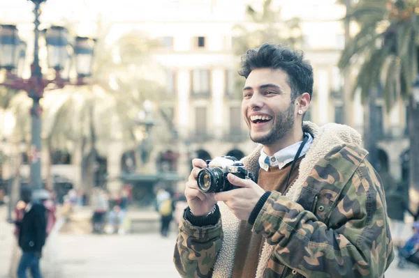 handsome young man taking pictures at the street