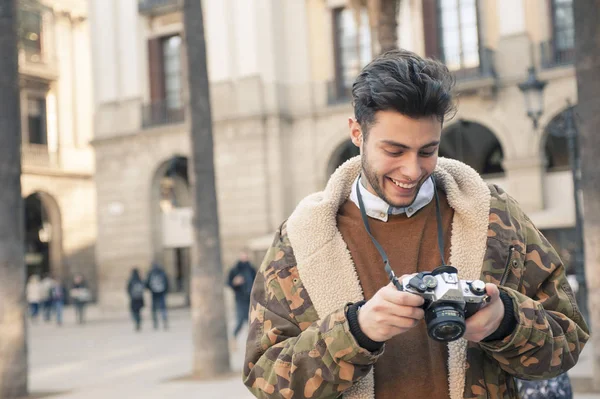 handsome young man taking pictures at the street