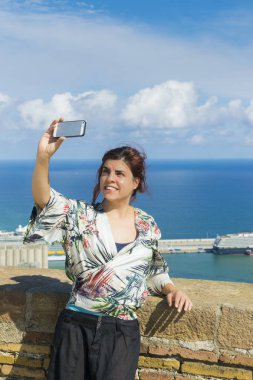 Turistik yer istimal hareket eden telefon arka plan üzerinde liman manzaralı kadında