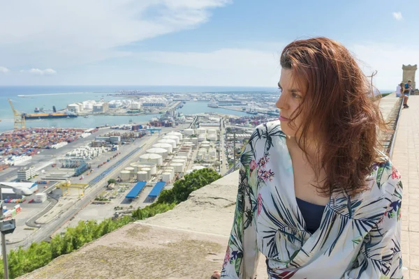 Woman standing in tourist place with cloudy sky and port view on background